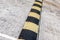 Striped black and yellow artificial road roughness, speed limit