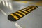 Striped black and yellow speed bump on a road