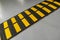 Striped black and yellow speed bump on a road