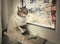 Striped cat sits on the windowsill, looking at the rain.