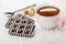 Striped chocolate cookies, teaspoon, sugar cubes, cup of tea