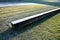 Striped composition in the park. strips of tiles and benches made of solid beams of a prismatic shape equally intersect the orname