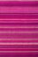 Striped fabric texture with multiple warm colors purple, purple, magenta, pink, red, maroon, orange, yellow. Close-up of the