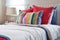 Striped headboard with Colourfull pillows and striped pillow on white bed