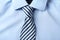 Striped male necktie on blue shirt