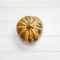 Striped pumpkin on white wooden background