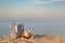 Striped summer bag with straw hat and sunglasses on beach, calm sea background. Sunset time. Copyspace