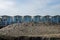 Striped white and blue striped beach houses and black sandy beach.