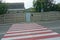 Striped white red pedestrian crossing on gray asphalt road