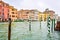 Striped and wooden mooring poles along sides of Grand Canal in Venice, Italy.