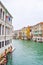 Striped and wooden mooring poles in water along sides of Grand Canal in Venice, Italy