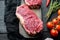 Striploin steak, raw beef butchery cut, on black wooden table