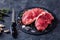 Striploin steaks on a black stone plate