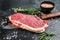 Striploin, strip loin steak or new York. Raw beef. Black background. Top view