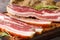 Stripy cured pork side bacon pancetta smoked on wood chip closeup on the wooden board. Horizontal