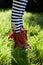 Stripy legs and red boots on grass.