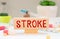 Stroke prostate text card on the doctor's desk next to a thermometer, stethoscope and tablets