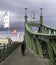 Strolling along Budapest`s Freedom Bridge, with its characteristic green beams topped by eagles, Hungary