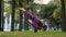 Strong active Muslim girl in hijab woman yogi sportswoman doing yoga workout in park on green lawn doing balance