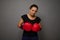 Strong African woman poses against gray wall background with red boxing gloves. Concept of Black Friday and boxing Day, Blow to