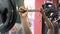 Strong Afro-American man lifting the barbell with the help of trainer, sport