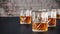 Strong alcoholic drinks, glasses and glasses, in the presence of whiskey, brandy. on a dark background of an old wooden table