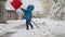 Strong amidst the storm, a little boy cleans his path through the huge snowfall, facing winter\'s cold challenge