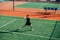 Strong athletic girl playing tennis on a court, ready to return overhead ball