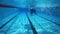 Strong athletic man swimming underwater in clear spa pool