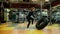 Strong athletic woman flipping large tractor tire in slow motion in gym