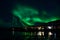 Strong aurora borealis over hill and houses