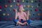 A strong baby climber posing for photographer at artificial wall.