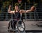 Strong basketball player in wheelchair pose with a ball on open gaming ground.