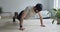 Strong bearded man doing push ups exercise at home