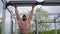 strong bearded young male training abdominal abs muscles hanging on crossbar and lifting legs