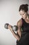 Strong Beautiful fitness woman lifting dumbbell weights