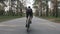 Strong cyclist riding a bicycle out of the saddle. Cyclist with strong leg muscles pedaling. Back follow shot. Cycling concept.