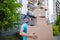 Strong delivery man holding a stack of a cardboard boxes