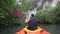 strong elder man floats kayak to gray cliff