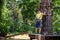 Strong excited young boy playing outdoors in rope park. Caucasia