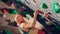 Strong Experienced Rock Climber Practicing Solo Climbing on Bouldering Wall in Gym. Man Exercising