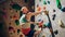 Strong Experienced Rock Climber Practicing Solo Climbing on Bouldering Wall in Gym. Man Exercising