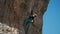 strong female rock climber trying to climb hard tough rock route on overhanging cliff