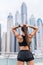 Strong fit female athlete getting ready for workout towards the skyscrapers. Strong fitness woman tying ponytail. Motivation and