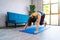 Strong fitness girl in athletic exercise clothes doing a plank workout. Asian woman training at home in her living room