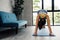 Strong fitness girl in athletic exercise clothes doing a plank workout. Asian woman training at home in her living room