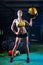 A strong girl in a gym trains with the ball. Health, sport concept