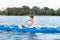 Strong handsome sportsman enjoying his time while rowing in canoe