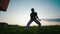 Strong hardy man dancing capoeira, stands on one hand, holding the body in the air