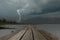 Strong lightning in black clouds over the lake